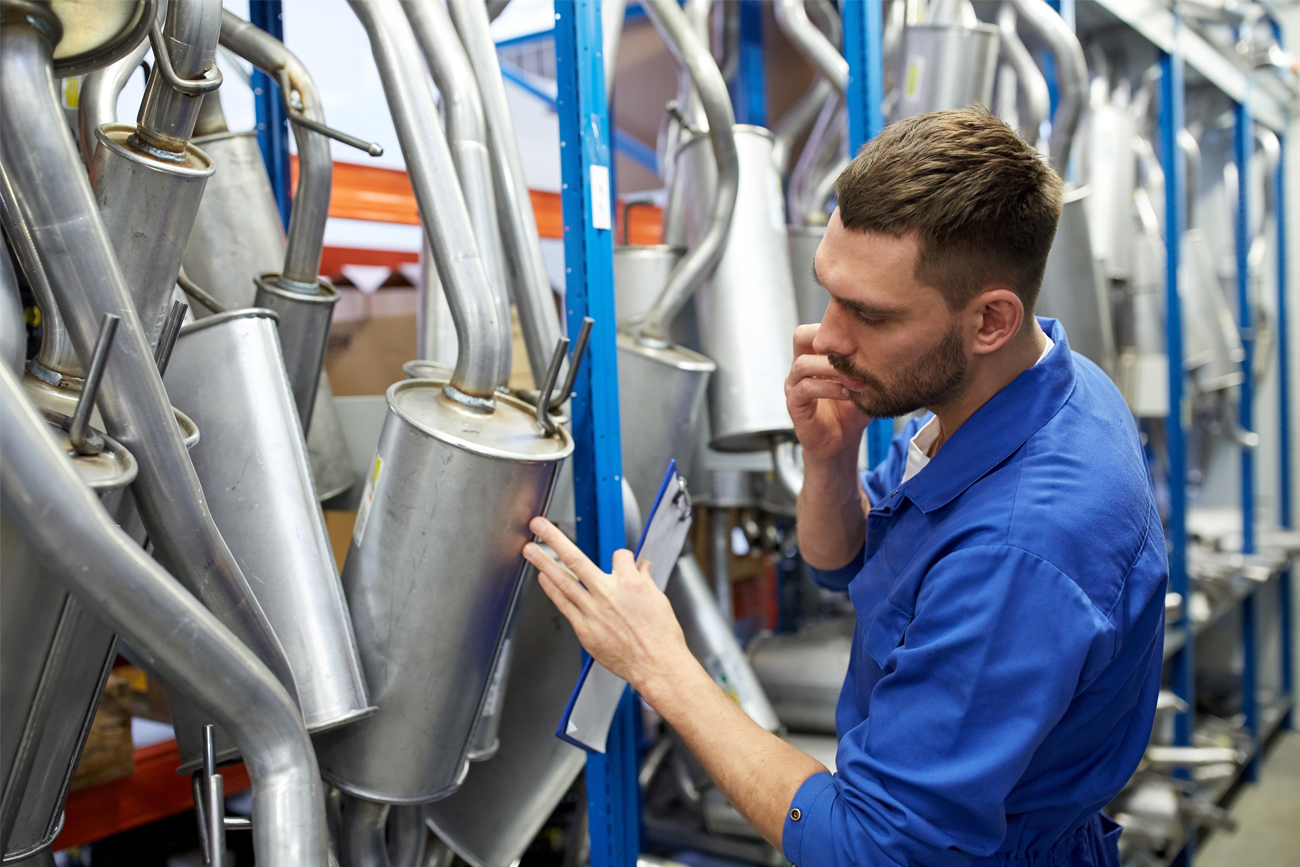 Automotive manufacturing employee carrying out check for quality assurance inventory.
