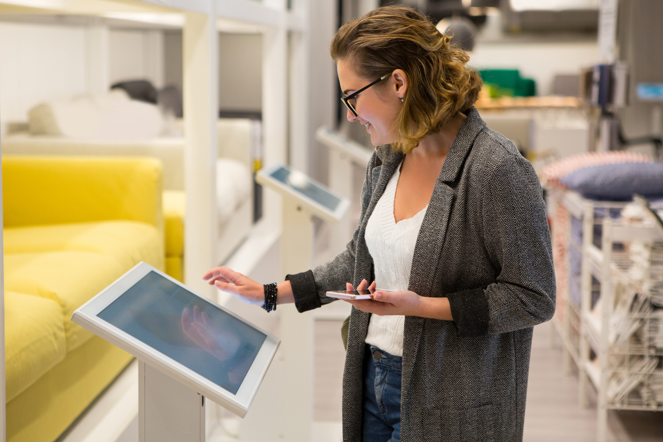 Customer at home-ware store checking stock on hand using tablet.